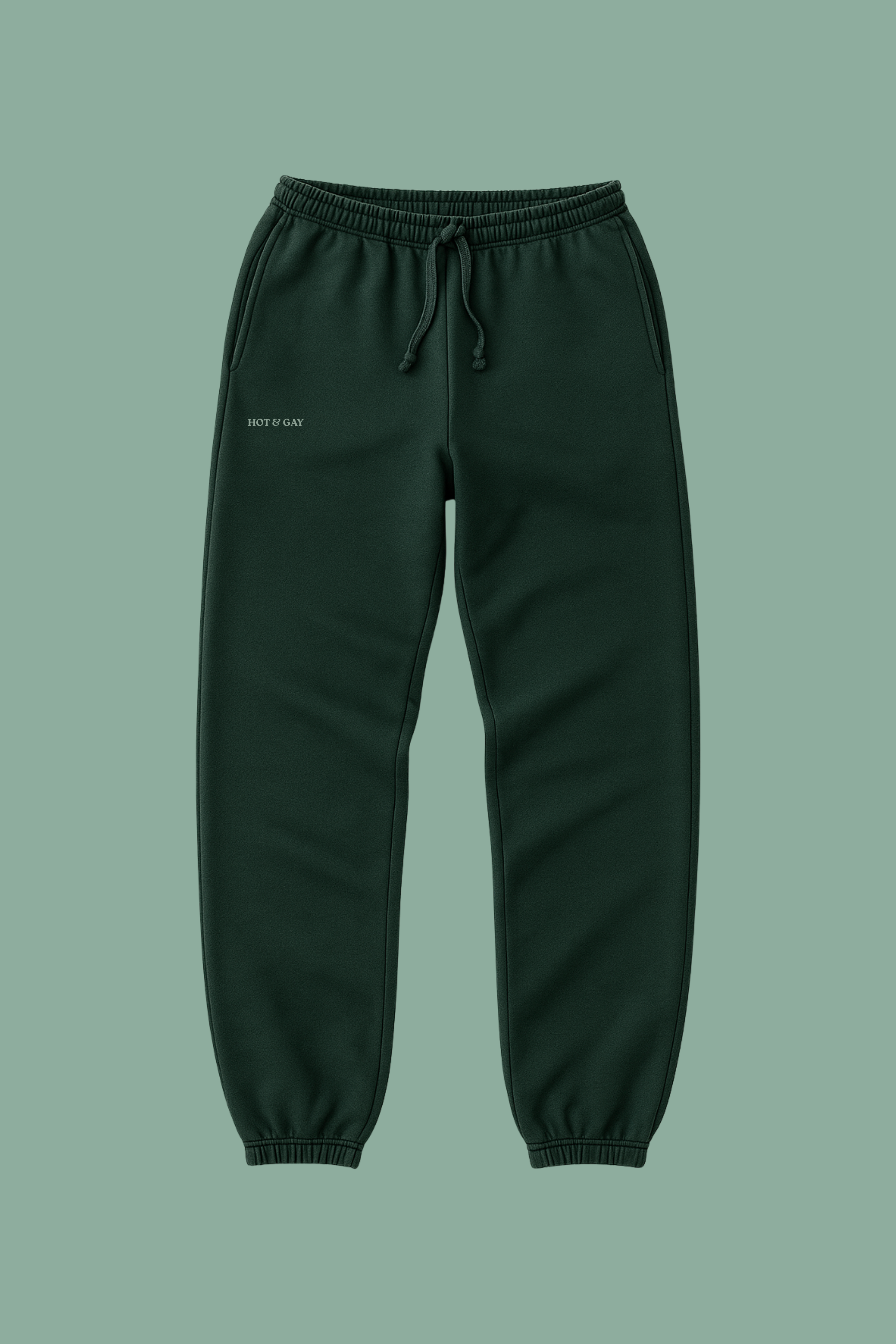 Dark green sweatpants on a solid green background with HOT & GAY embroidered