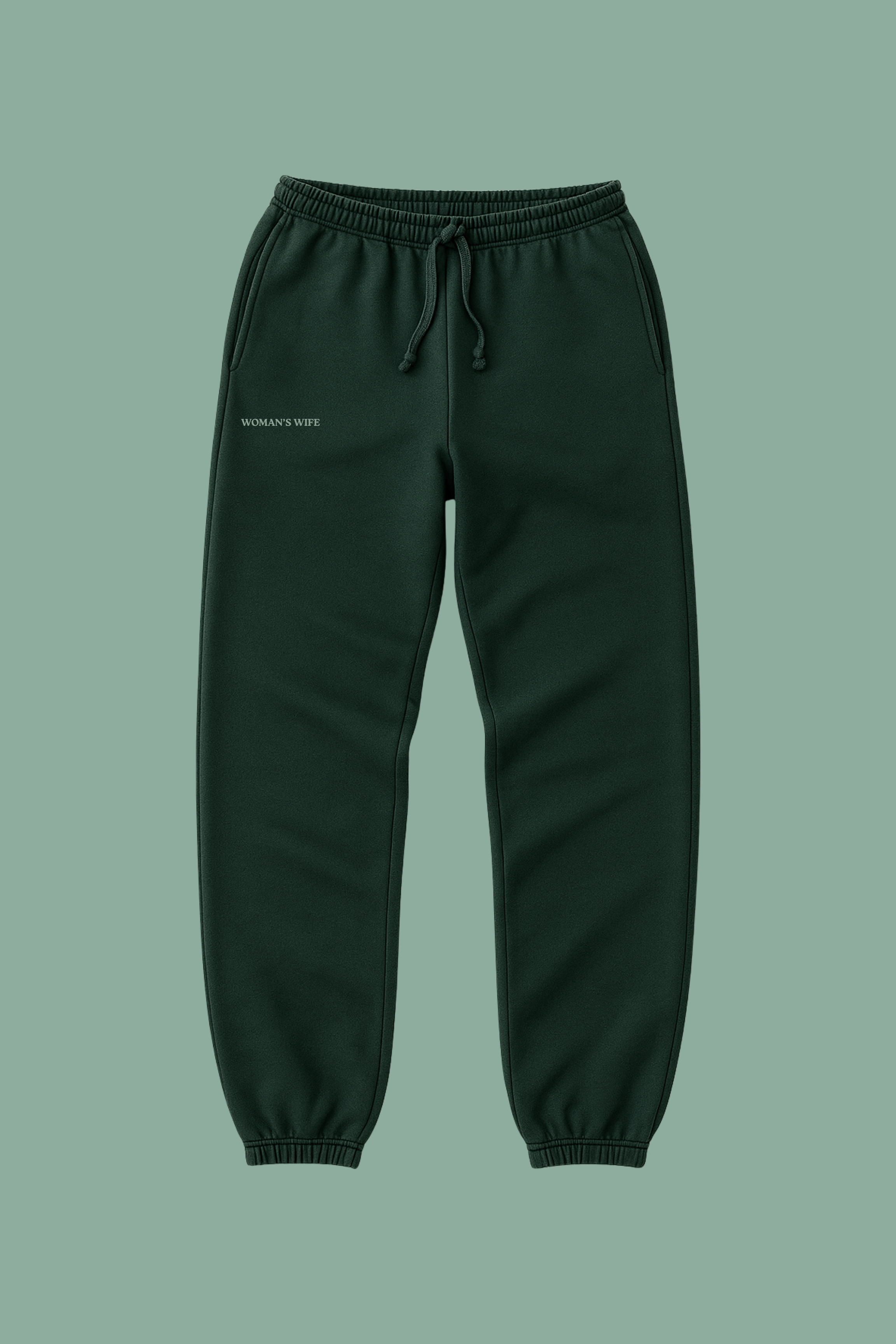 Dark green sweatpants on a solid green background with 'WOMAN'S WIFE' embroidered
