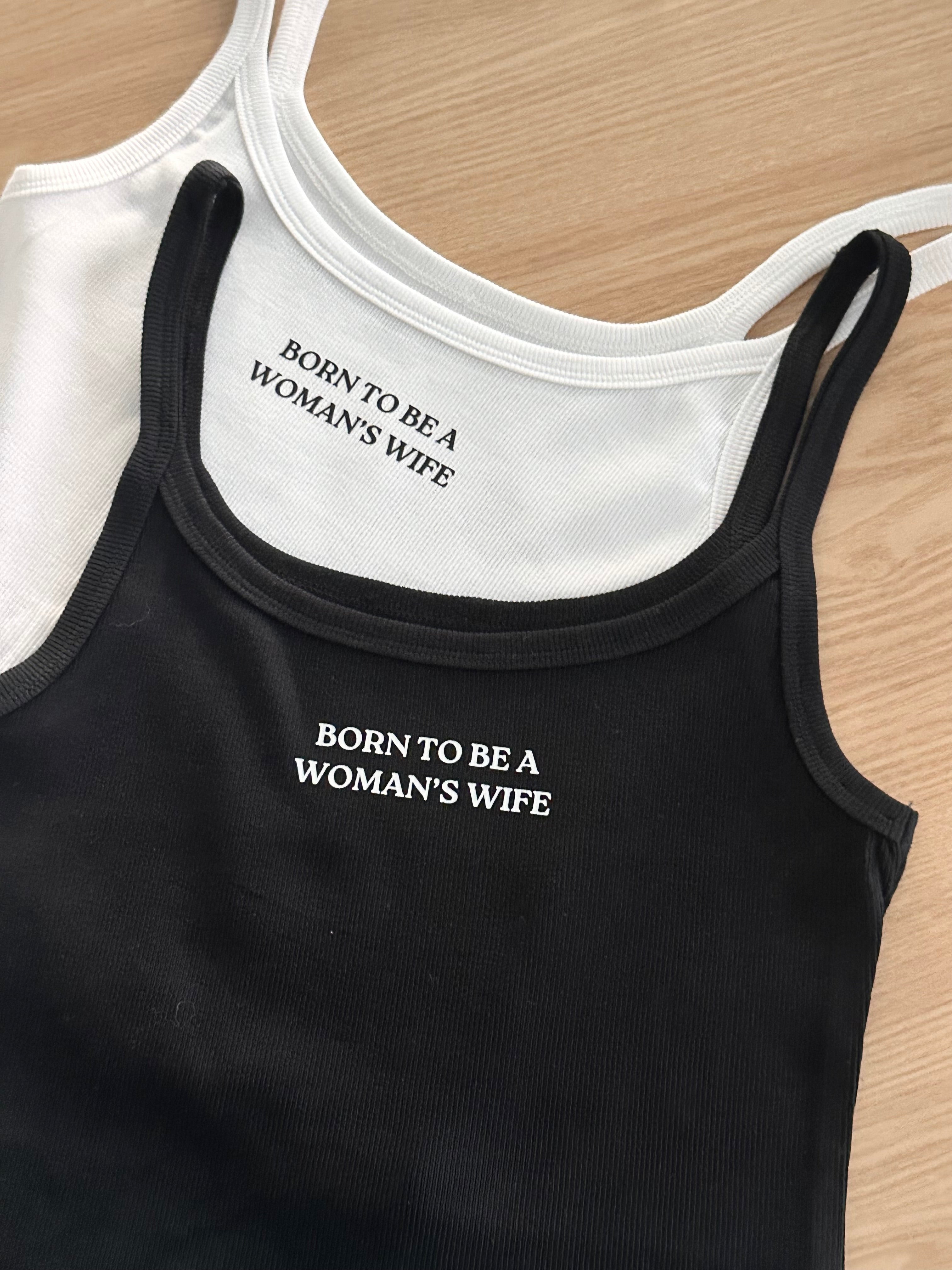 Black and white tank tops with 'Born to be a woman's wife' text.
