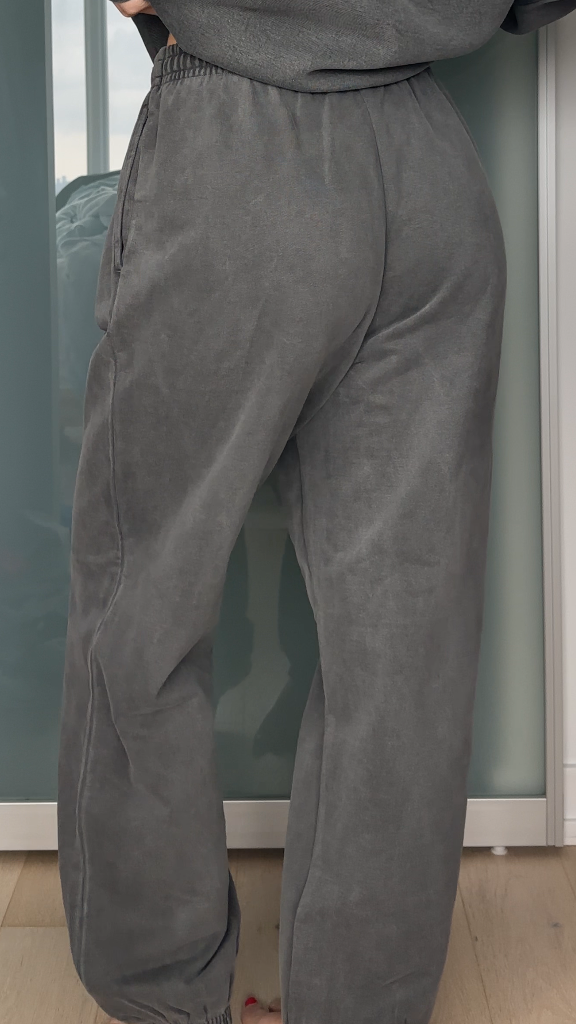 Person wearing gray sweatpants against a neutral background